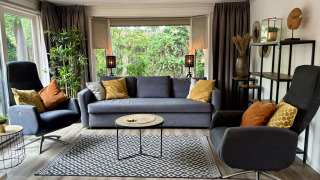 Moderne woonkamer in Cozy Lodge bij Bungalowpark Het Verscholen Dorp, Nederland, met bank en fauteuils.