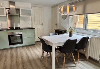 Cucina luminosa e zona pranzo al Cozy Lodge, Bungalowpark Het Verscholen Dorp, Paesi Bassi, stile moderno.