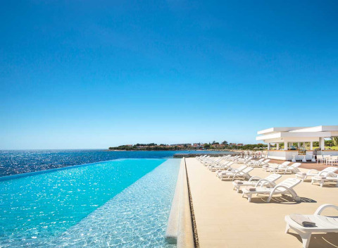 Piscina a sfioro e lettini ad Aminess Planet Camping Sirena in Istria, Croazia, con vista sul mare azzurro.