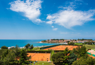 Uitzicht op tennisbanen, kust en stad bij Aminess Planet Camping Sirena, een vakantiepark in Istrië, Kroatië.