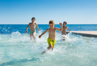 Kinderen rennen en spelen in het water bij Aminess Planet Camping Sirena, een vakantiepark in Istrië, Kroatië.