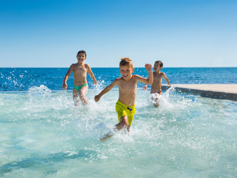 Kinderen rennen en spelen in het water bij Aminess Planet Camping Sirena, een vakantiepark in Istrië, Kroatië.