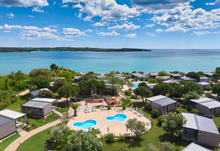 Vista aérea del parque vacacional Aminess Planet Camping Sirena con cabañas, piscina y mar en Istria, Croacia.