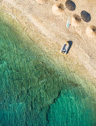 Luchtfoto van Aminess Planet Camping Sirena met parasols en helder water aan het strand in Istrië, Kroatië.