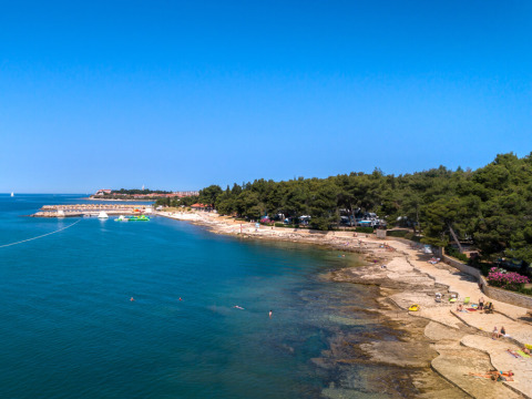 Luchtbeeld van Aminess Planet Camping Sirena in Istrië, Kroatië, met rotsstrand en badgasten.