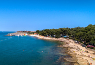 Luchtfoto van Aminess Planet Camping Sirena in Istrië, Kroatië, met rotsstrand en zwemmers.