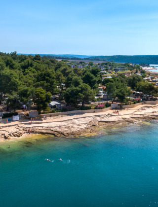Küstennahe Campingplätze und Strände bei Novigrad, Istrien, Kroatien, mit kristallklarem Wasser und Pinienwald.
