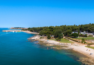 Littoral au Aminess Planet Camping Sirena en Istrie, Croatie, avec eau bleue, plage et arbres luxuriants.