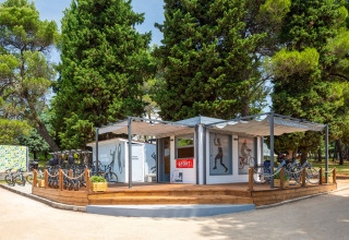 Centro deportivo en Aminess Planet Camping Sirena, Istria, Croacia, con bicicletas y pinos alrededor.