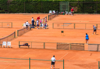 Persone giocano a tennis sui campi in terra rossa di Aminess Planet Camping Sirena in Istria, Croazia.