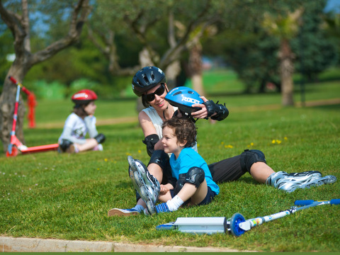 Famille avec enfants en rollers et casques profitant d'une journée au parc d'Aminess Planet Camping Sirena, Istrie.