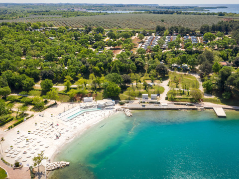 Aerial view of Valamar Camping Lanterna showing pools, beach, lush greenery, and holiday homes in Istria, Croatia.
