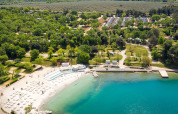 Luchtbeeld van Valamar Camping Lanterna met zwemzone, strand, bomen en chalets in Istrië, Kroatië.