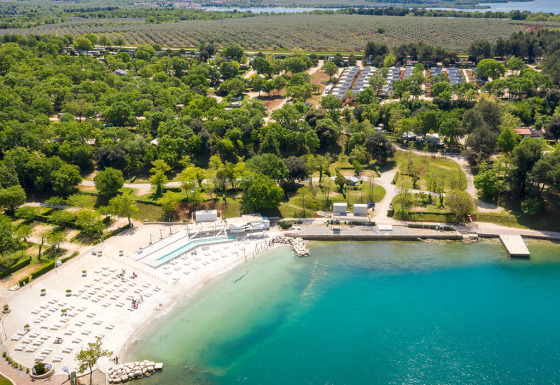 Vue aérienne de Valamar Camping Lanterna avec piscines, plage, arbres et hébergements de vacances en Istrie, Croatie.