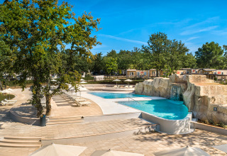 Outdoor swimming pool area with sun loungers and umbrellas at Valamar Camping Lanterna, Istria, Croatia.