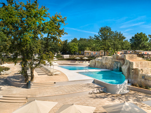 Udendørs poolområde med liggestole og parasoller på Valamar Camping Lanterna, Istrien, Kroatien.