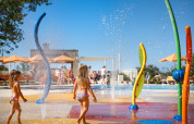 Bambini che giocano nell’area giochi d’acqua colorata al Valamar Camping Lanterna, Istria, Croazia.