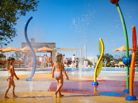 Niños jugando en un colorido parque acuático con fuentes en Valamar Camping Lanterna, Istria, Croacia.
