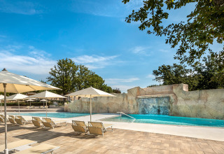 Buitenzwembad met ligzetels, parasols en waterval bij Valamar Camping Lanterna, Istrië, Kroatië.