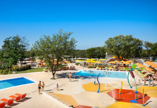 Gezinnen ontspannen aan het zwembad met speelzone in Valamar Camping Lanterna, Istrië, Kroatië.