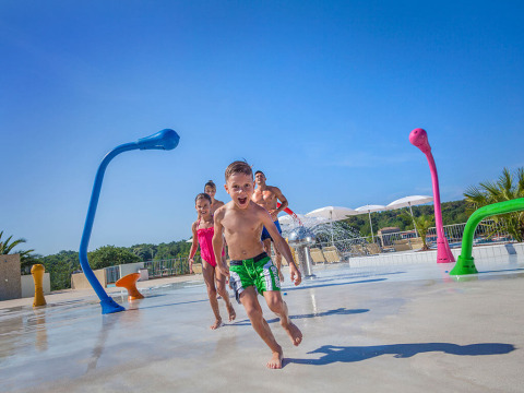 Niños juegan y corren por un parque de agua en Valamar Camping Lanterna en Istria, Croacia.