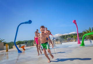 Kinder rennen lachend durch einen Wasserspielplatz im Valamar Camping Lanterna, Istrien, Kroatien.