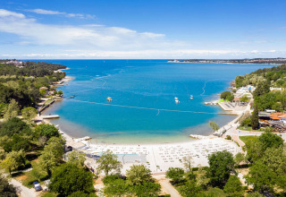 Vista aérea de la playa y el mar azul en Valamar Camping Lanterna, un parque vacacional en Istria, Croacia.