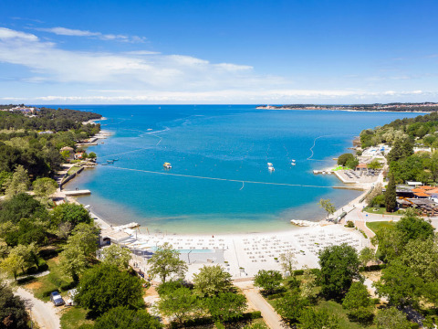 Aerial view of the beach and turquoise sea at Valamar Camping Lanterna holiday park in Istria, Croatia.