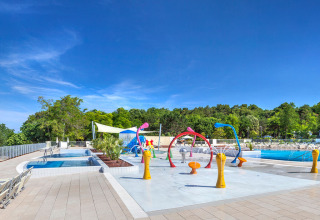 Außenpool und bunte Wasserspielzone im Valamar Camping Lanterna Ferienpark in Istrien, Kroatien, unter blauem Himmel.