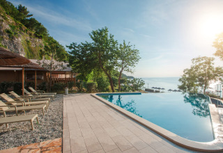 Piscina a sfioro con lettini e vista mare presso la tenda glamping al Valamar Camping Lanterna, Croazia.