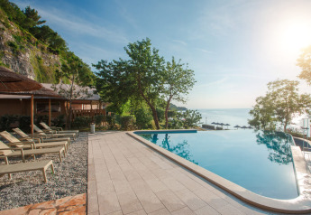 Infinitypool met ligzetels en zeezicht bij de glamping tent aan Valamar Camping Lanterna, Kroatië.