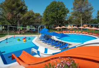 Außenpool mit Wasserrutsche, Liegestühlen und Sonnenschirmen bei Maro Home im Valamar Camping Lanterna, Kroatien.