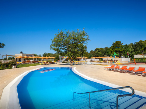 Piscine extérieure et transats au Valamar Camping Lanterna, Istrie, Croatie, sous un ciel ensoleillé.