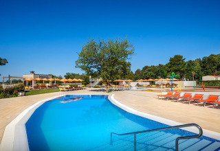 Outdoor swimming pool with sun loungers at Valamar Camping Lanterna, Istria, Croatia, on a sunny day.
