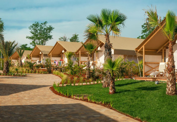 Maro Premium Glamping-tenten op Valamar Camping Lanterna in Kroatië, met palmbomen en groene grasvelden.
