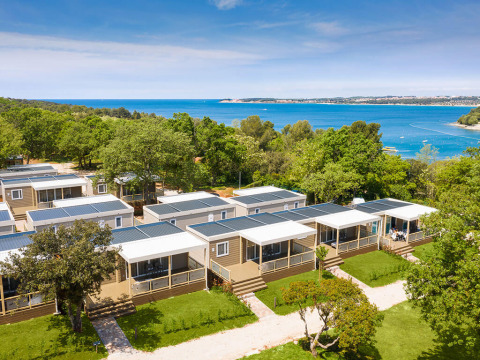 Vakantiechalets omgeven door groen aan zee bij Valamar Camping Lanterna in Istrië, Kroatië.