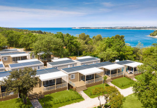 Vakantiechalets omgeven door groen aan zee bij Valamar Camping Lanterna in Istrië, Kroatië.