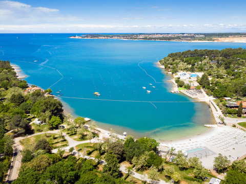 Luftaufnahme von Valamar Camping Lanterna in Istrien, Kroatien, mit Strand, klarem Wasser und Wald.