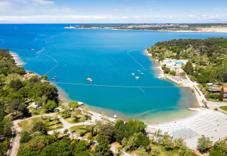 Luftaufnahme von Valamar Camping Lanterna in Istrien, Kroatien, mit Strand, klarem Wasser und Wald.