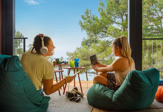Due giovani donne si rilassano sui pouf godendosi la vista al Valamar Camping Lanterna in Istria, Croazia.