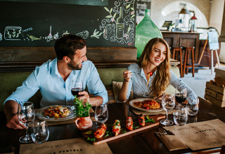 Couple enjoying dinner with wine at a restaurant in Valamar Camping Lanterna, Istria, Croatia, relaxed atmosphere.