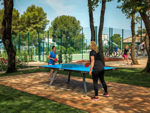 Due donne giocano a ping pong all'aperto al Valamar Camping Lanterna, villaggio vacanze in Istria, Croazia.