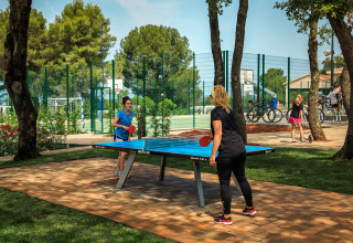 Twee vrouwen spelen buiten tafeltennis bij Valamar Camping Lanterna, een vakantiepark in Istrië, Kroatië.