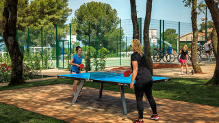 Due donne giocano a ping pong all'aperto al Valamar Camping Lanterna, villaggio vacanze in Istria, Croazia.