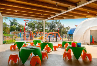 Area giochi per bambini con tavoli e sgabelli colorati al Valamar Camping Lanterna, Istria, Croazia.