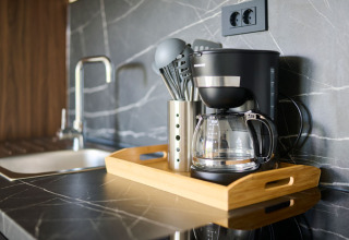 Cucina di casa vacanze moderna con macchina da caffè e utensili su vassoio ad Aminess Planet Camping Sirena, Croazia.
