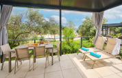 Overdekt terras bij Premium Holiday Home op Aminess Planet Camping Sirena met stoelen, tafel en ligstoelen.