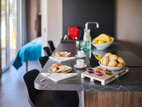 Encimera de cocina moderna con bollos, fruta, café y mermeladas en una cabaña de lujo en Croacia.