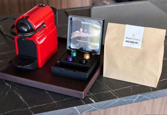 Rode Nespresso-machine met koffiecapsules en welkomstpakket op een werkblad in een vakantiewoning in Kroatië.