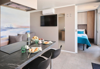 Intérieur moderne d’une cabine avec salle à manger et chambre à Aminess Planet Camping Sirena en Croatie.